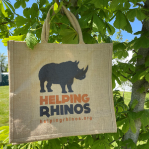 Bag with helping rhinos logo in front of a tree